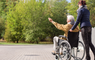 caregiver pushing client in wheelchair outside